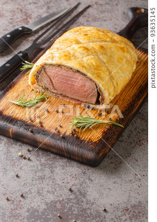 Perfect homemade juicy Beef Wellington, tenderloin dish on rustic wooden board. Vertical 93635145