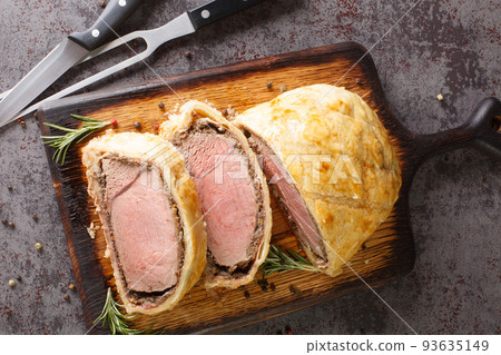 Beef Wellington classic steak dish closeup on wooden board. Horizontal top view Beef Wellington classic steak dish closeup on wooden board. Horizontal top view 93635149