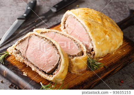 Medium Beef Wellington classic sliced steak closeup on wooden board. Horizontal Medium Beef Wellington classic sliced steak closeup on wooden board. Horizontal 93635153