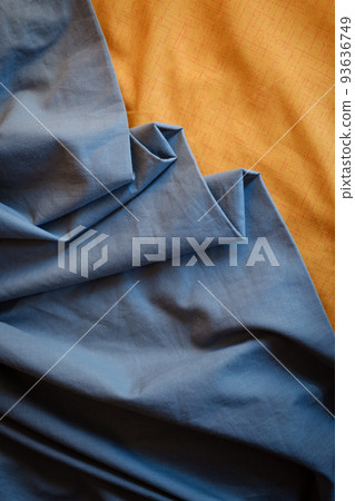 Bicolor background gray orange fabric, crumpled fabric folds, selective focus 93636749