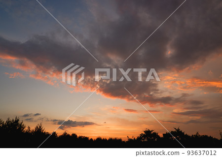 The sky at sunset before bad weather. Low red sunlight illuminates thunderclouds. 93637012