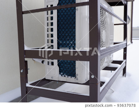 The outdoor unit of the air conditioner (air-to-air heat pump) in the snow during winter operation. The outdoor unit of the air conditioner (air-to-air heat pump) in the snow during winter operation. 93637078