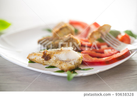 Pieces of fried hake fish in a plate with pepper Pieces of fried hake fish in a plate with pepper 93638328