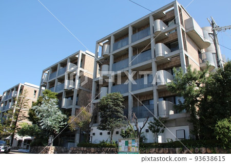 A beautiful five-story urban apartment with earth-colored tiles and exposed concrete that shines against the blue sky A beautiful five-story urban apartment with earth-colored tiles and exposed concrete that shines against the blue sky 93638615