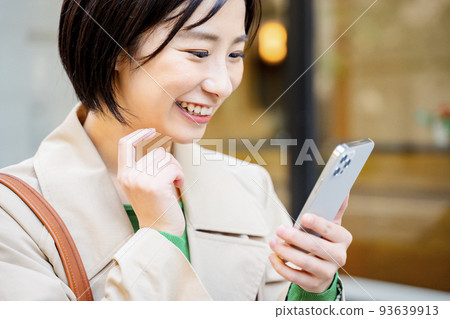 一個在戶外拿著智能手機的女人 一個在戶外拿著智能手機的女人 93639913