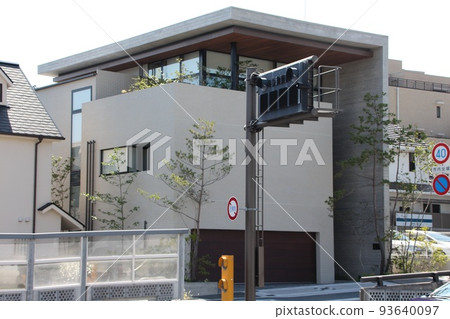 A modern, stylish and stylish mansion with an L-shaped roof wall and cube-shaped exposed concrete walls. 93640097