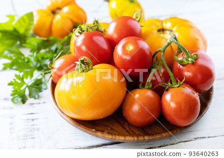 Raw organic vegetables. The concept of vegan or diet food. Fresh ripe bunch colorful tomatoes, red, yellow on a wooden table. Raw organic vegetables. The concept of vegan or diet food. Fresh ripe bunch colorful tomatoes, red, yellow on a wooden table. 93640263