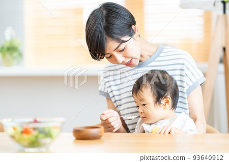 Mother giving food to baby Mother giving food to baby 93640912