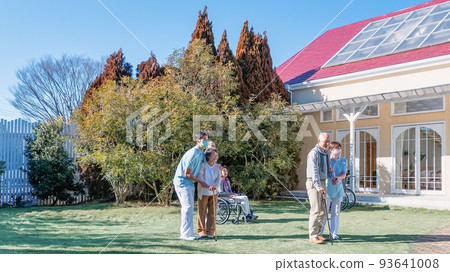 Rehabilitation Center Elderly people and care staff taking an afternoon walk in the courtyard 93641008