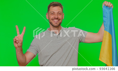 Young man hold Ukraine national flag, showing victory sign against war, hoping for success and win 93641166