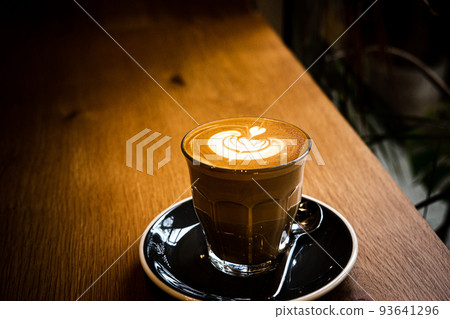 A cup of coffee latte top view with leaf shape foam A cup of coffee latte top view with leaf shape foam 93641296