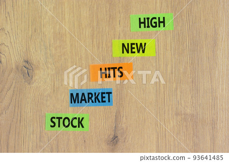 Stock market hits new high symbol. Concept words Stock market hits new high on color papers on a beautiful wooden background. Business and stock market hits new high concept. Copy space. Stock market hits new high symbol. Concept words Stock market hits new high on color papers on a beautiful wooden background. Business and stock market hits new high concept. Copy space. 93641485