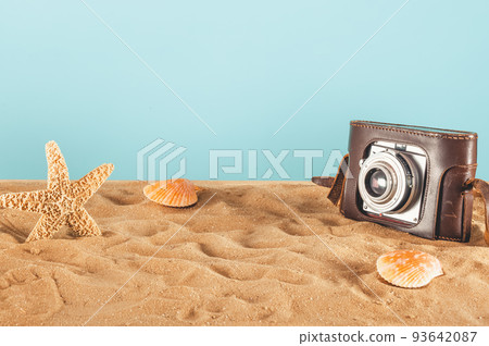 Background of beach with seashells, starfish and a retro photo camera 93642087