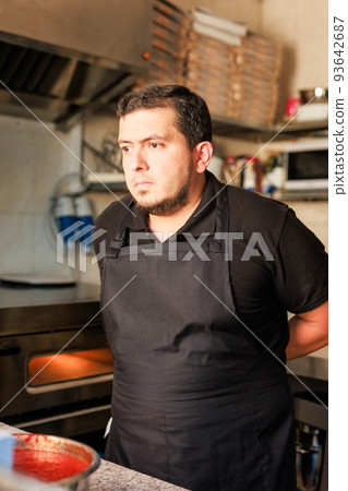 Latin Pizzeria chef cook pizza in professional uniform. restaurant italian cuisine entrepreneur Latin Pizzeria chef cook pizza in professional uniform. restaurant italian cuisine entrepreneur 93642687