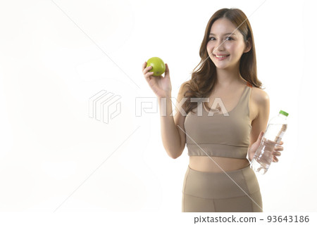 Pretty asian woman with apple and water on white background. Pretty asian woman with apple and water on white background. 93643186