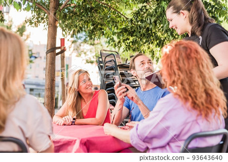 mature group order food in restaurant. waitress using smartphone and tablet application technology 93643640