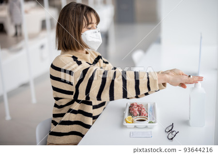 Woman disinfects hands with sanitizer ar restaurant Woman disinfects hands with sanitizer ar restaurant 93644216
