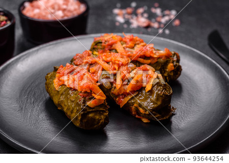 Dolma, stuffed grape leaves with rice and meat on a dark background Dolma, stuffed grape leaves with rice and meat on a dark background 93644254