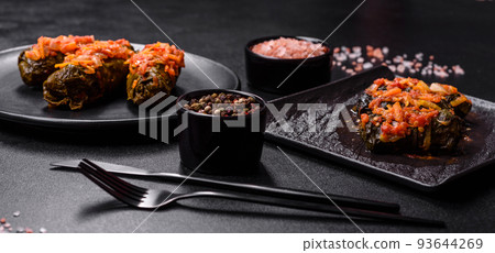 Dolma, stuffed grape leaves with rice and meat on a dark background Dolma, stuffed grape leaves with rice and meat on a dark background 93644269