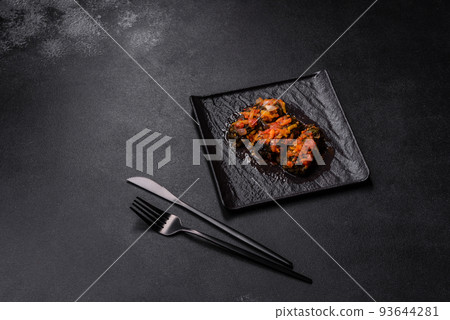 Dolma, stuffed grape leaves with rice and meat on a dark background Dolma, stuffed grape leaves with rice and meat on a dark background 93644281