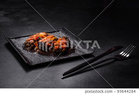 Dolma, stuffed grape leaves with rice and meat on a dark background Dolma, stuffed grape leaves with rice and meat on a dark background 93644284