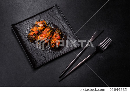 Dolma, stuffed grape leaves with rice and meat on a dark background Dolma, stuffed grape leaves with rice and meat on a dark background 93644285