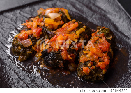 Dolma, stuffed grape leaves with rice and meat on a dark background Dolma, stuffed grape leaves with rice and meat on a dark background 93644291