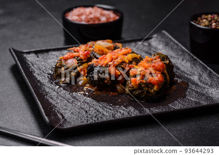 Dolma, stuffed grape leaves with rice and meat on a dark background 93644293