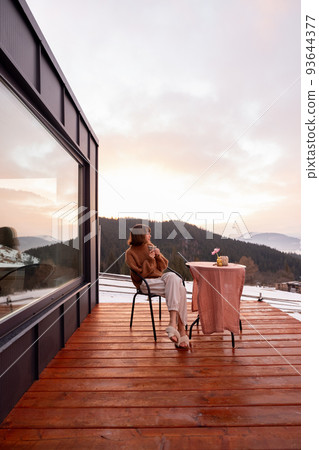 Woman resting at small house in the mountains Woman resting at small house in the mountains 93644377