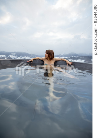 Woman bathing in hot tub at mountains Woman bathing in hot tub at mountains 93644390