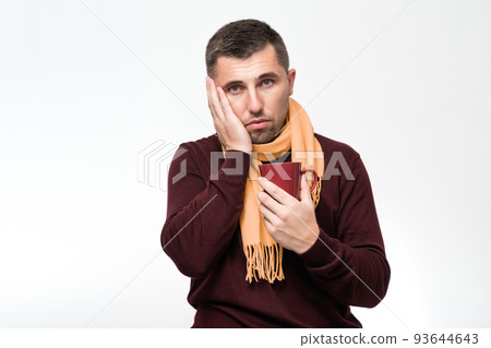 A handsome man touches his mouth with his hand with a pained expression because of toothache or tooth disease, dentist concept. 93644643