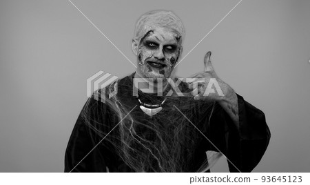 Sinister man Halloween zombie raises thumbs up agrees with something or gives positive reply, likes 93645123