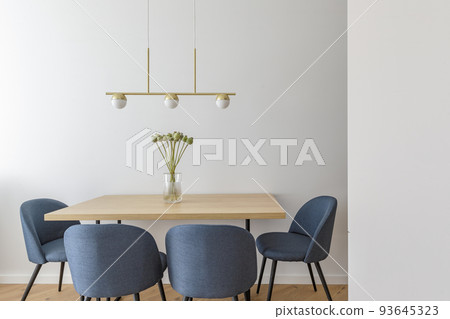 Modern minimalist kitchen and dining room interior design  with wooden furniture, oak floor. blue chairs.  Aesthetic simple interior design concept. 93645323