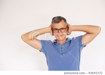 Portrait of happy mature man wearing glasses covering ears 93645372