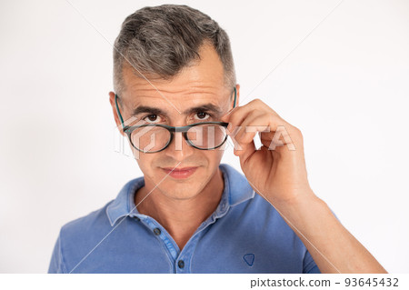 Portrait of serious mature man looking over spectacles Portrait of serious mature man looking over spectacles 93645432