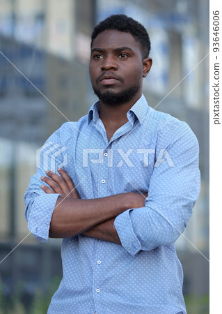 Stylish African American businessman with arms folded stands thinking about own business 93646006