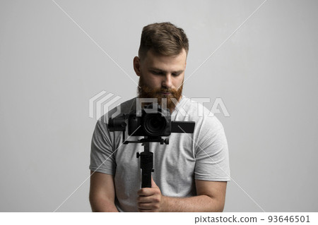 Professional filmmaker with a dslr camera on 3-axis gimbal stabilizer. Filmmaking, videography, hobby and creativity concept. 93646501