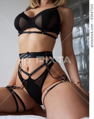 Young woman on her bed wearing black underwear. 93647505