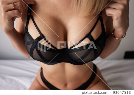 Young woman on her bed wearing black underwear. Young woman on her bed wearing black underwear. 93647518