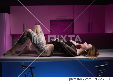 sexy girl in erotic underwear in the kitchen on the table in neon light 93647591