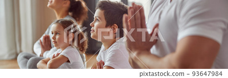 Serene family doing yoga together at home 93647984