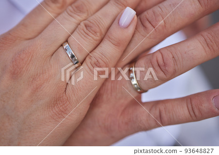 Newly wed couple's hands with wedding rings. Newly wed couple's hands with wedding rings. 93648827
