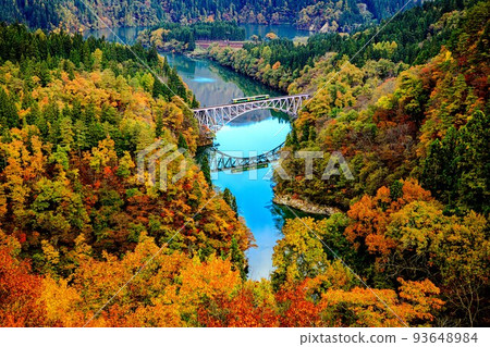 Tadami Line Kiha E120 train crossing the No. 1 Tadami River Bridge in autumn colors (Mishima Town, Fukushima Prefecture, early November) 93648984