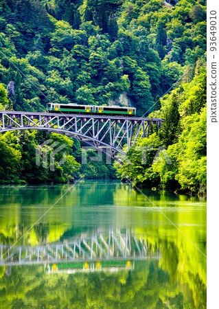 Tadami Line Kiha E120 train crossing the fresh green Daiichi Tadami River Bridge (Mishima Town, Fukushima Prefecture, mid-May) 93649010