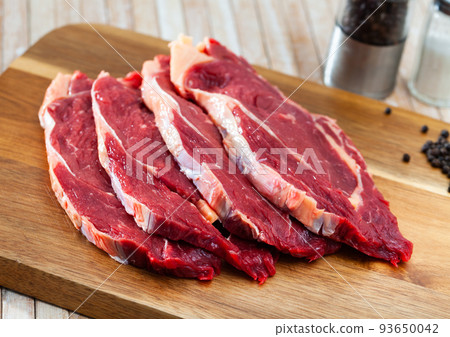close up of pieces of striploin on wooden table close up of pieces of striploin on wooden table 93650042