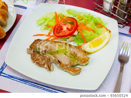 Scandinavian cuisine seafood served with greens and vegetables on plate on wooden table 93650524