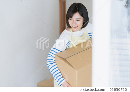 A woman cleaning up her luggage at her new home 93650730