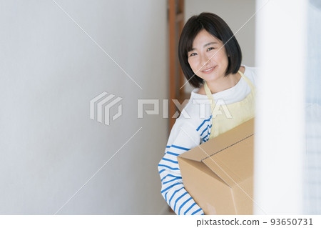 A woman cleaning up her luggage at her new home 93650731
