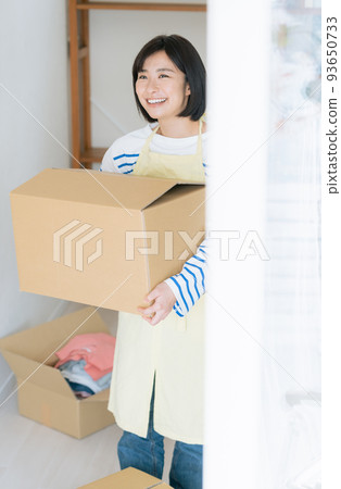一個女人在她的新家清理她的行李 93650733