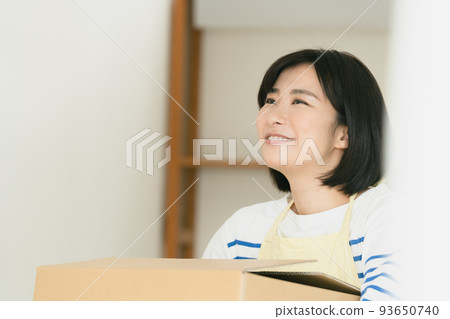 A woman cleaning up her luggage at her new home 93650740